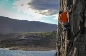 person climbing on rock formation during daytime