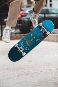 Crop skater jumping on skateboard